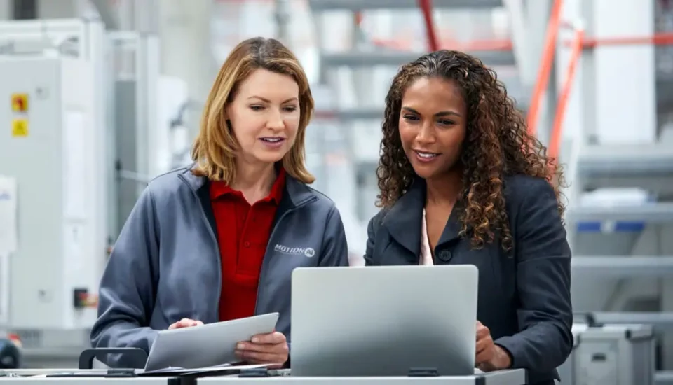 Two female Motion Ai co-workers reviewing reports in plant