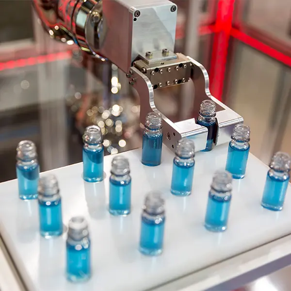 Close up image of robotic mechanical arm manipulating tubes full with a blue substance in a medical laboratory