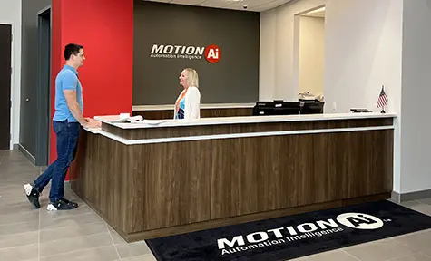 Male speaking with female receptionist in Motion Ai reception area