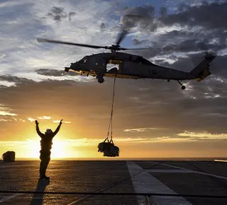Sea Hawk helicopters approach the aircraft carrier during a vertical replenishment