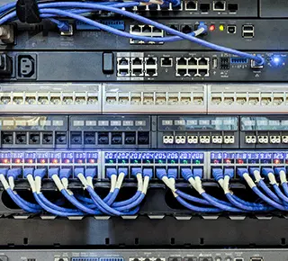 Computer network router / switch with many connected blue LAN cables