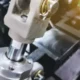 Close-up image of rod clevis of pneumatic cylinder on blurred machine background
