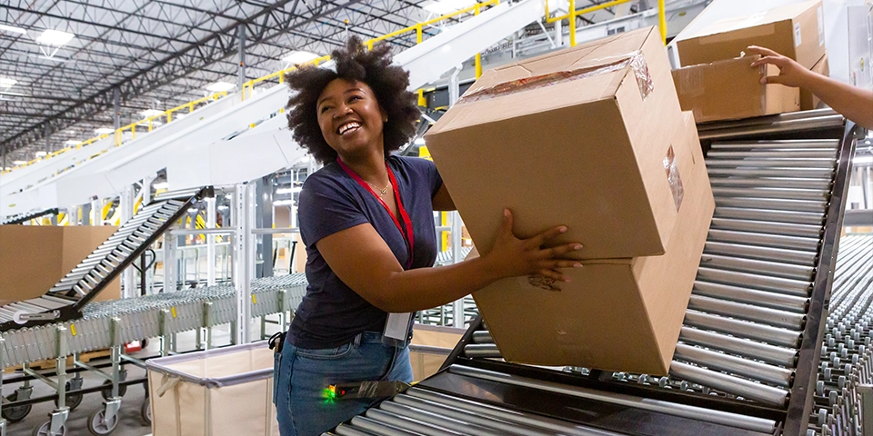 Cheerful warehouse employee loading boxes into truck