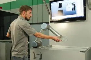 Man inspecting collaborative robot (cobot) arm