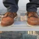Close-up of feet standing on a t-slot aluminum extrusion at a high elevation with city in the background