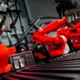 Line of six red collaborative robots (cobots) in a facility