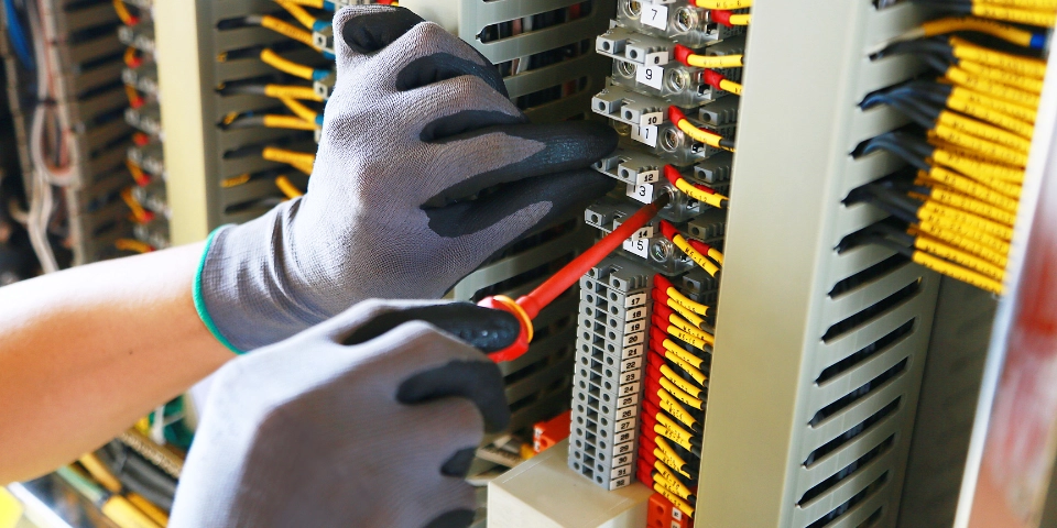 Man fixing a VFD problem wearing protective gloves