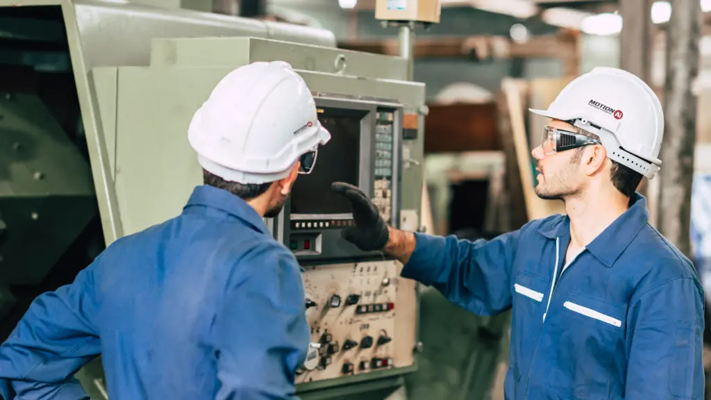 Two male technicians wearing safety equipment in factory